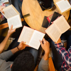 People in a reading group sitting around a table holding books
