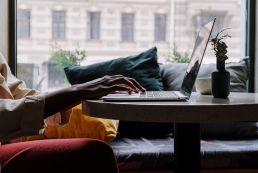 Hands typing on a laptop keyboard in a bright room, to show that Living Well UK is offering digital support for Census 2021